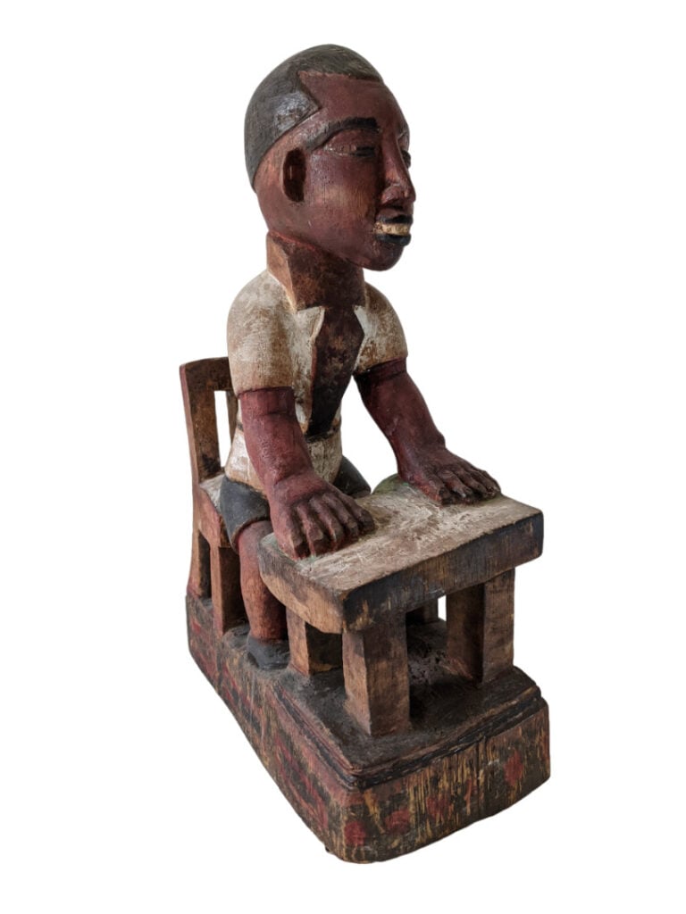 Statuette Baoulé (Côte d'Ivoire) en bois d'un écolier à sa table. Reste de coul…