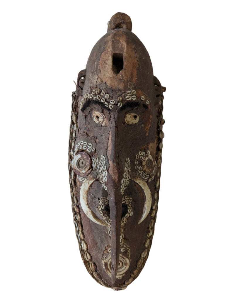 Un grand masque Sepick (Nouvelle Guinée) avec des restes de cauris et une patin…