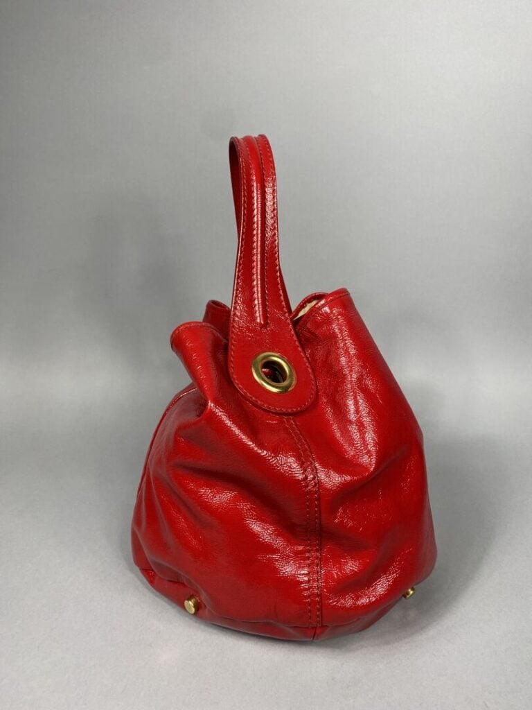 YVES SAINT LAURENT - Sac bourse en cuir rouge verni porté épaule , garniture do…