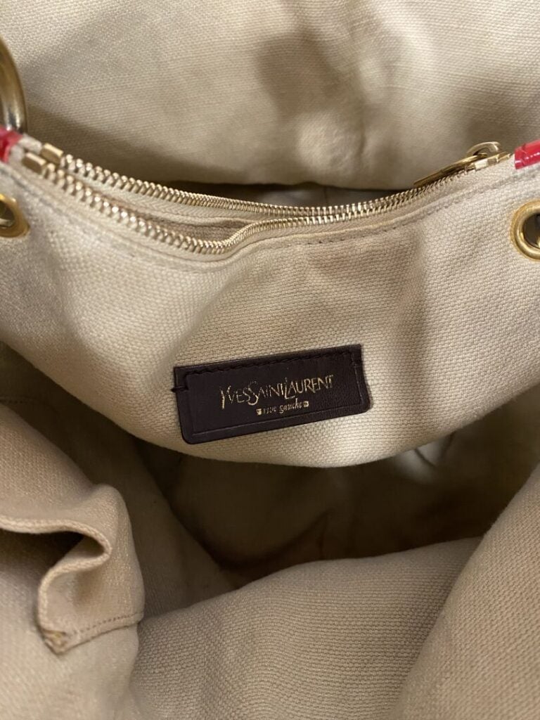 YVES SAINT LAURENT - Sac bourse en cuir rouge verni porté épaule , garniture do…