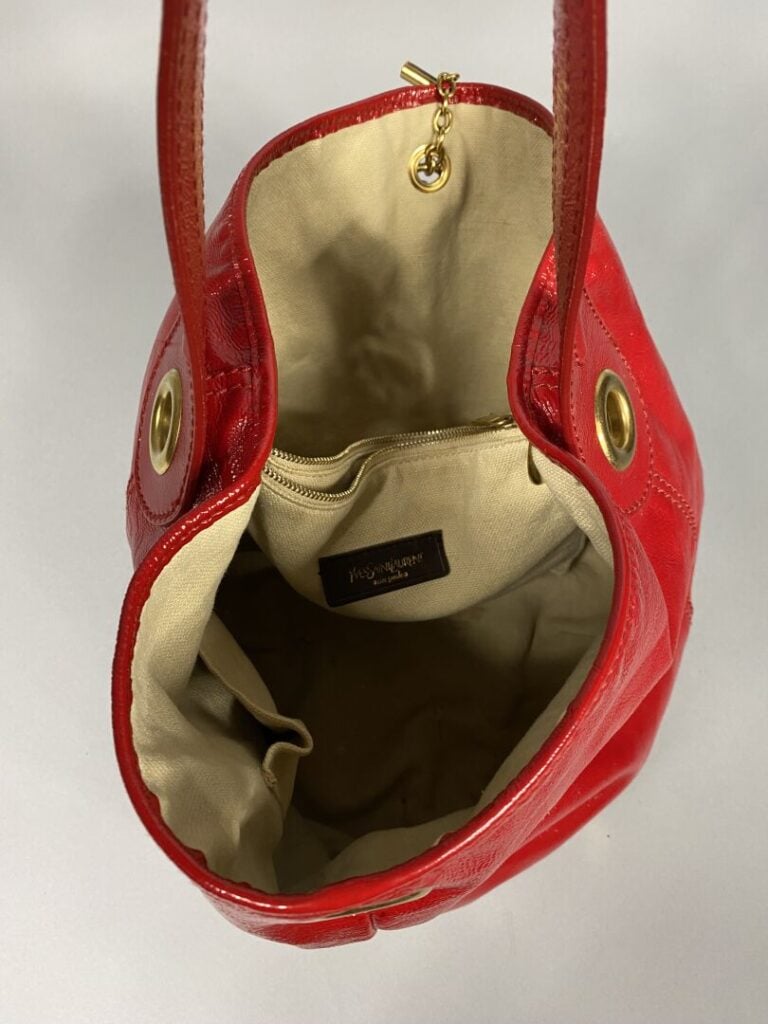 YVES SAINT LAURENT - Sac bourse en cuir rouge verni porté épaule , garniture do…