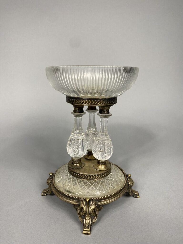 Coupe en verre taillé posant sur un piétement tripode en bronze à enroulements…