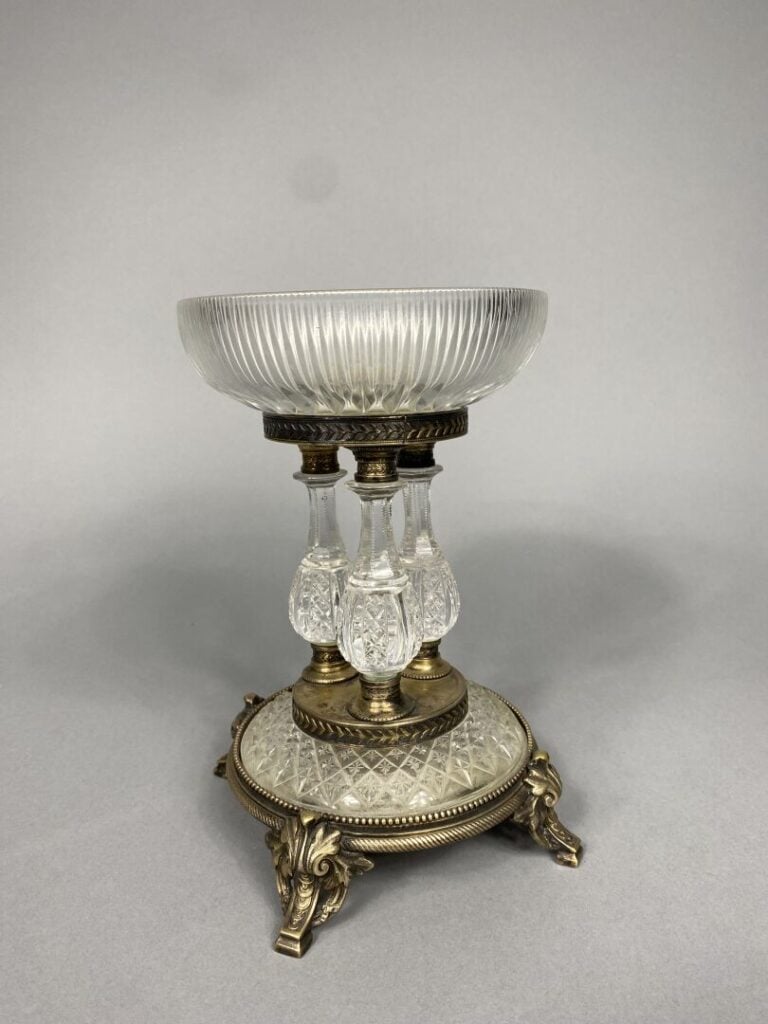 Coupe en verre taillé posant sur un piétement tripode en bronze à enroulements…