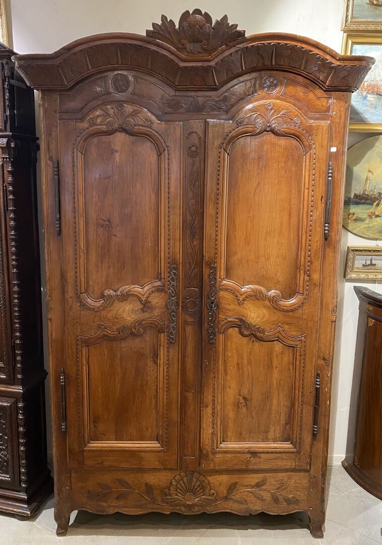 Grande armoire en noyer ouvrant à deux portes moulurées à décor sculpté de rinc…