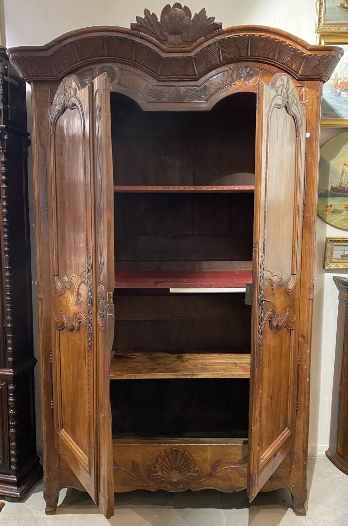 Grande armoire en noyer ouvrant à deux portes moulurées à décor sculpté de rinc…