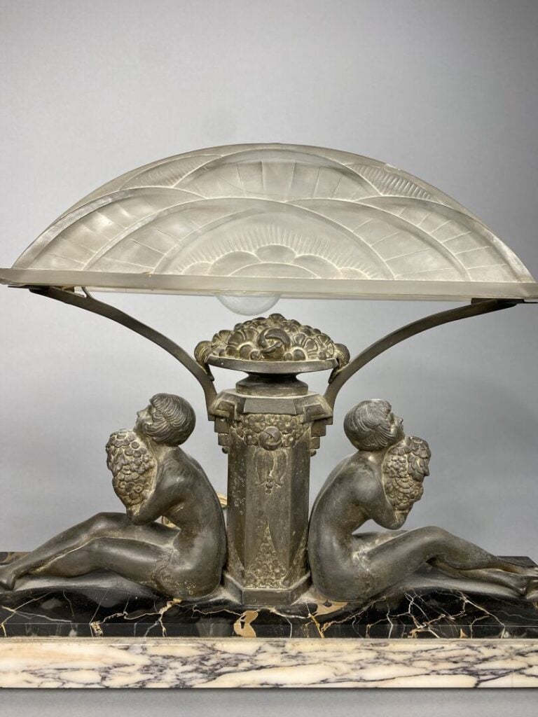 Lampe de bureau en régule patiné ornée de deux jeunes femmes adossées tenant un…