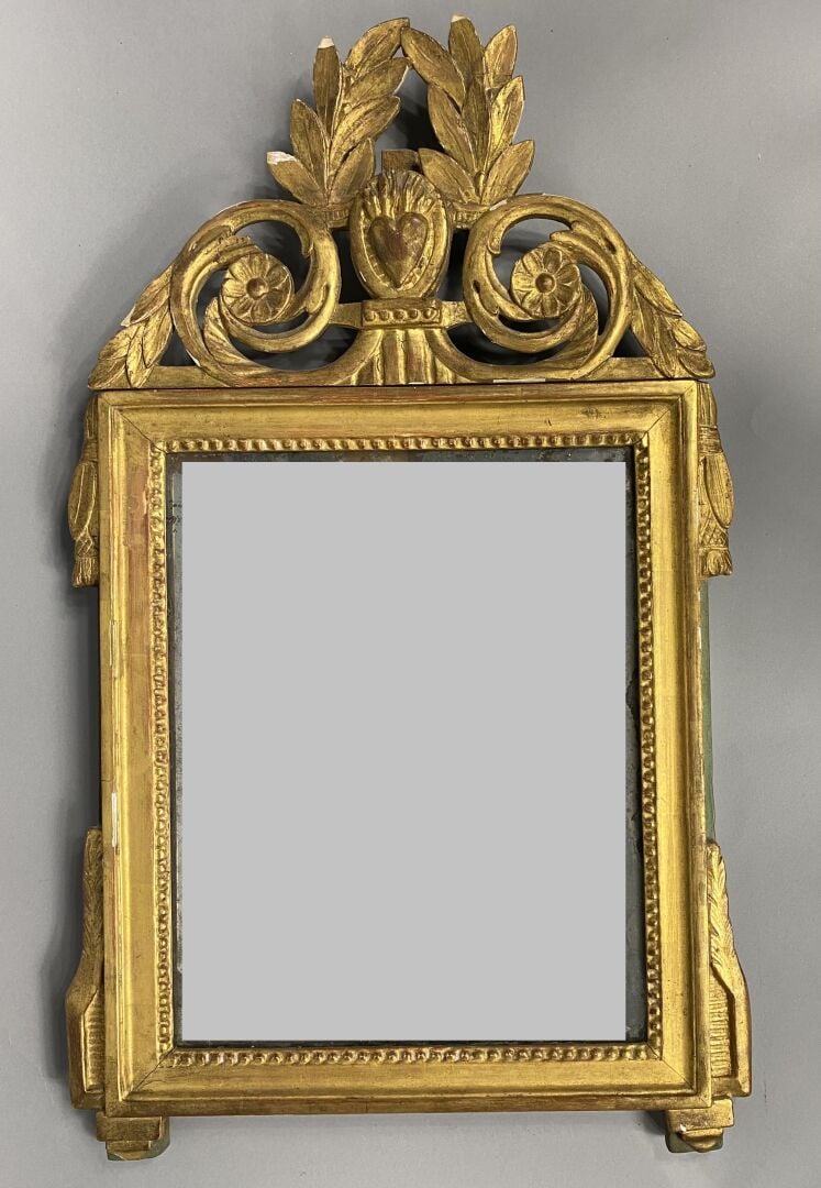 Miroir en bois doré mouluré et sculpté à décor de frise, le fronton ajouré orné…