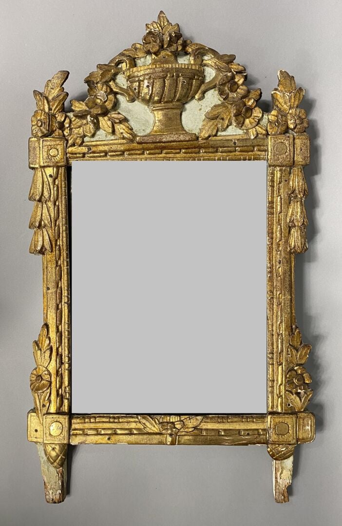 Miroir en bois et composition peint dans les tons doré, le fonton surmonté d'un…