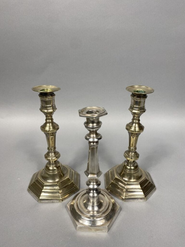 Paire de flambeaux en métal patiné posant un fût à pans, la base hexagonale en…