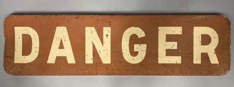 Enseigne en tôle peinte écrit "DANGER" sur fond rouge - Au dos inscription "vil…