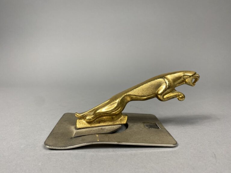 Sculpture en métal doré représentant un jaguar, mascotte de la marque automobil…