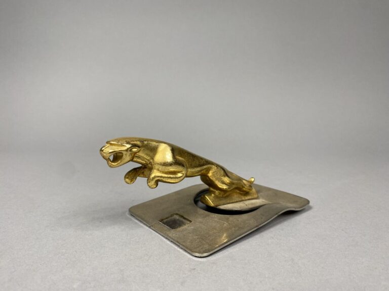 Sculpture en métal doré représentant un jaguar, mascotte de la marque automobil…