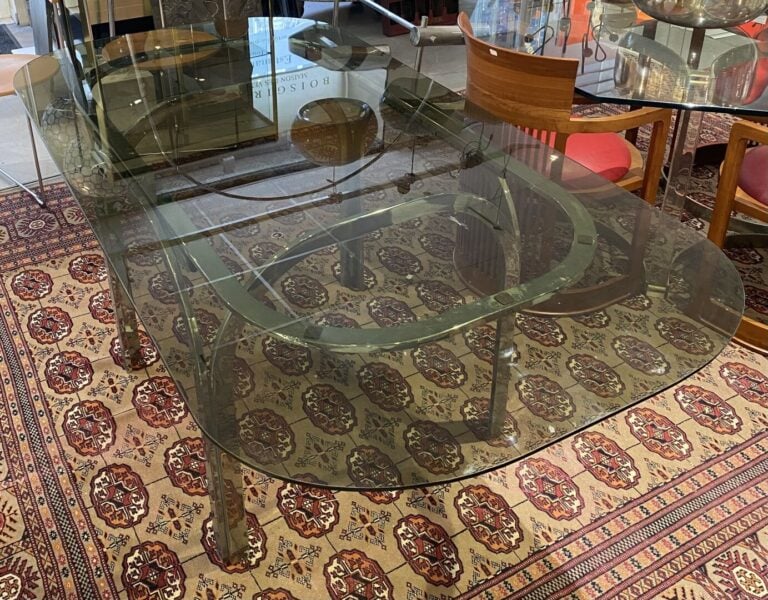 Table en métal chromé posant sur quatre pieds de forme arrondie retenant un pla…