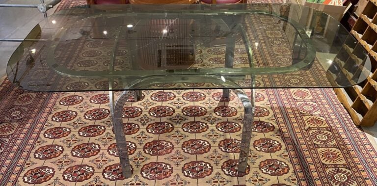Table en métal chromé posant sur quatre pieds de forme arrondie retenant un pla…