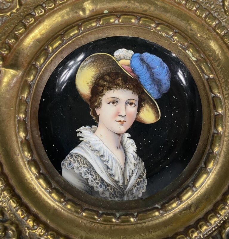 Assiette en porcelaine à décor d'une jeune fille au chapeau à plumes, entourage…