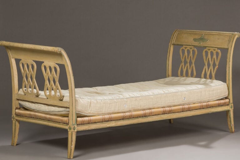 Banquette à deux montants renversés ornés d'un vase à l'antique sur piédouche,…