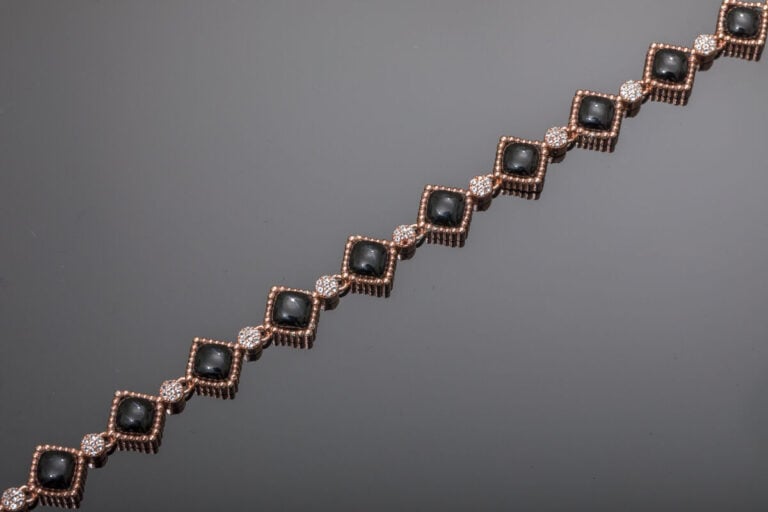 BRACELET en vermeil rose (925‰) à motifs losangiques godronnés, serti d'onyx et…