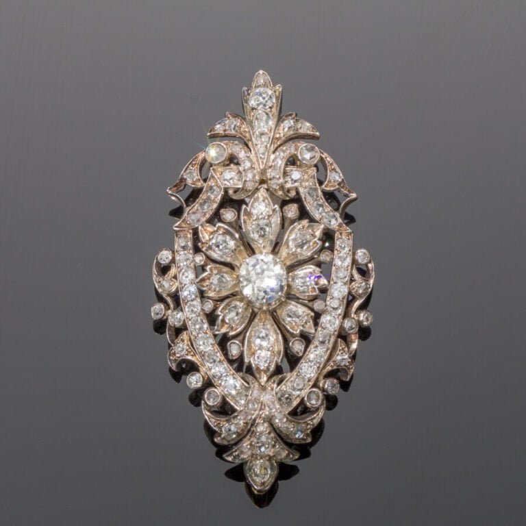 BROCHE en or jaune (750%) et argent (min. 800‰) ajourés, à motif de fleur, et v…