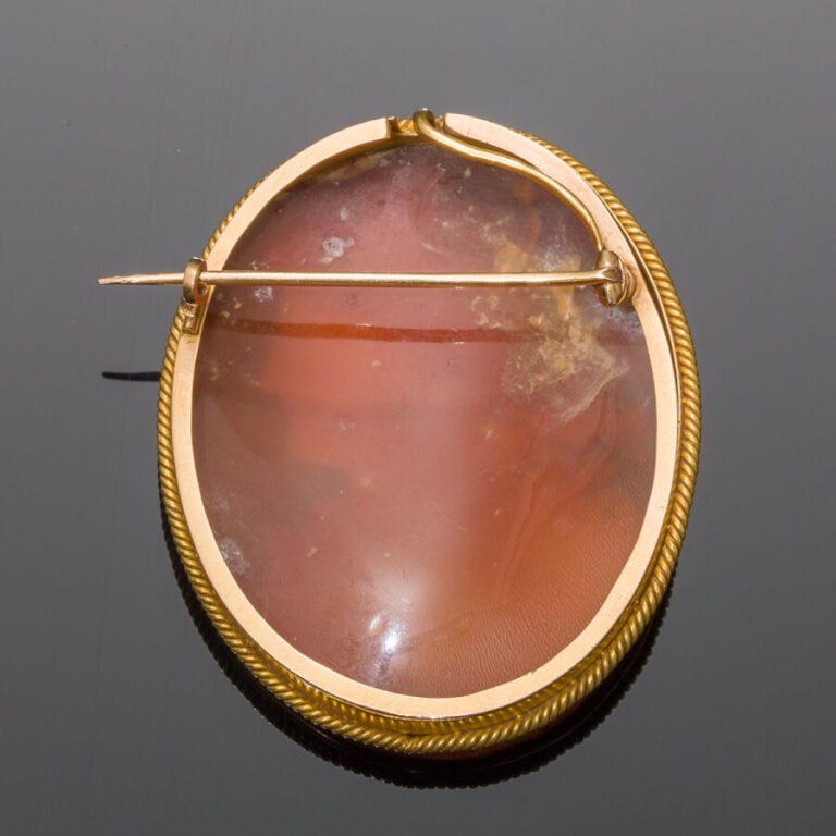 BROCHE ovale en or jaune (750‰) partiellement torsadé, orné d'un camée coquille…