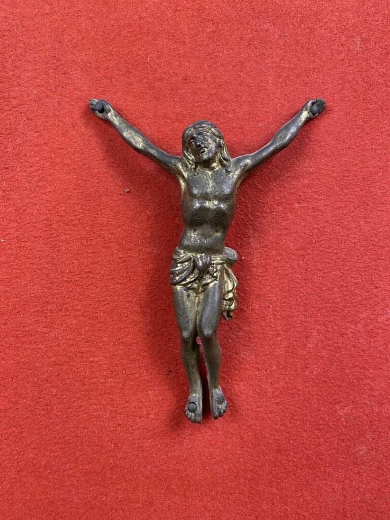 Christ en bronze représenté la tête inclinée vers son épaule droite, les genoux…