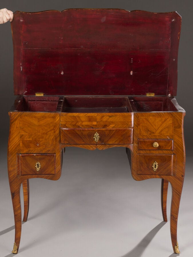 Coiffeuse en bois de placage marqueté ouvrant par un abattant découvrant des pe…