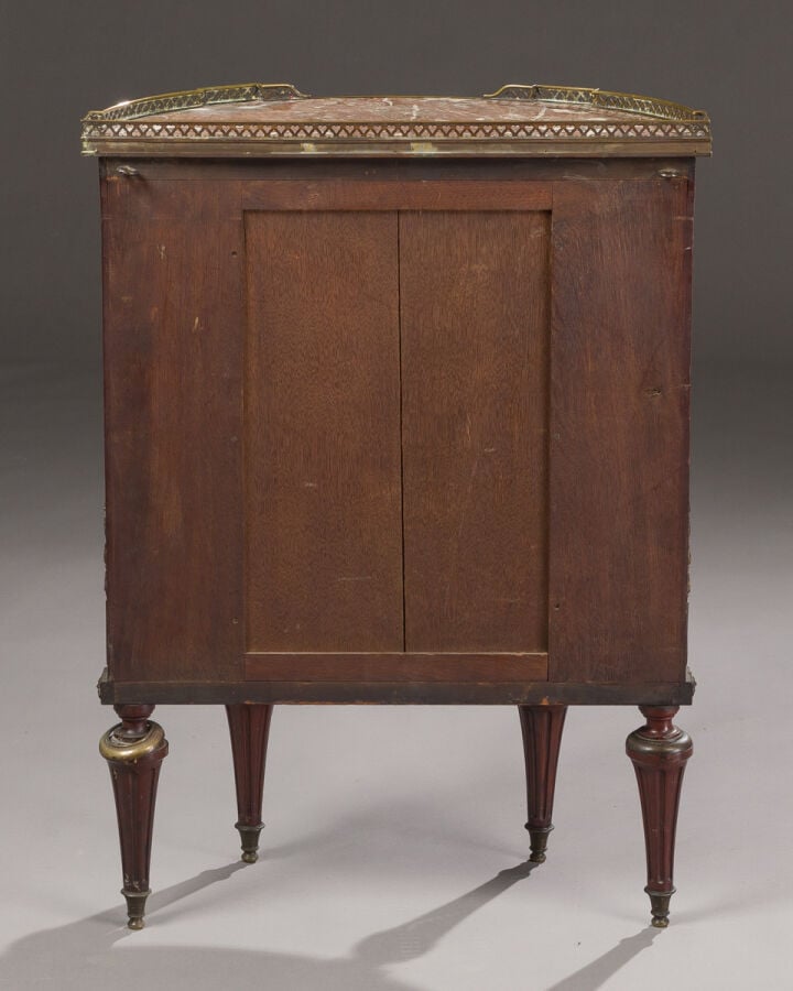 Commode demi-lune en acajou et placage d'acajou ouvrant par trois tiroirs. Dess…