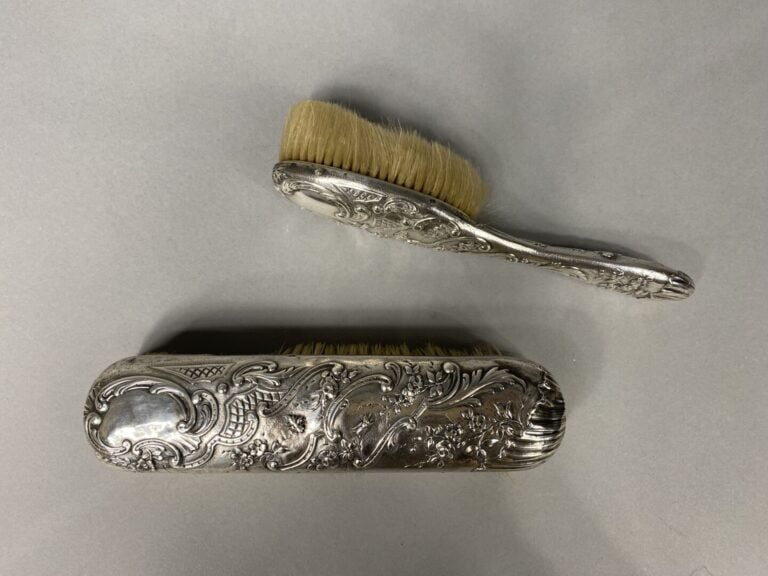 Deux brosses de toilette en argent (925) à décor repoussé de rinceaux feuilllag…