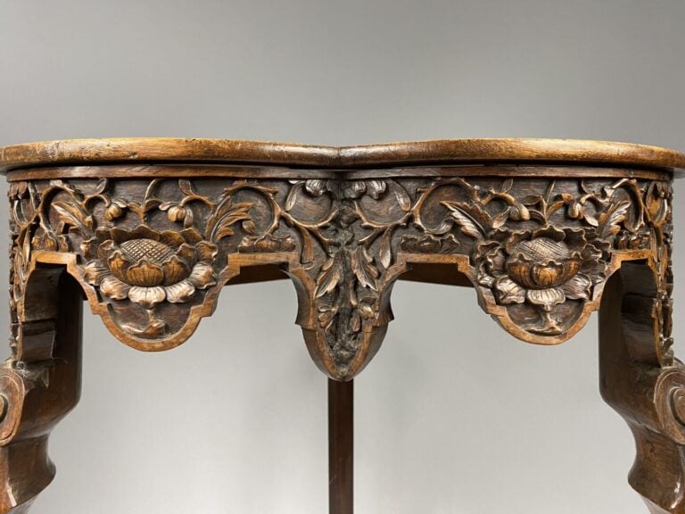 Encoignure en bois mouluré et sculpté de motifs feuillagés et fleurs, les pieds…