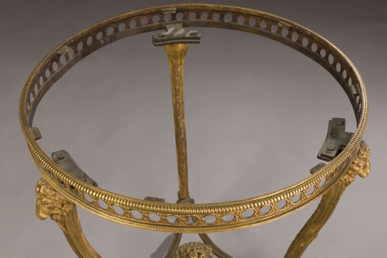 Guéridon circulaire en bronze ciselé doré posant sur trois pieds cambrés entret…