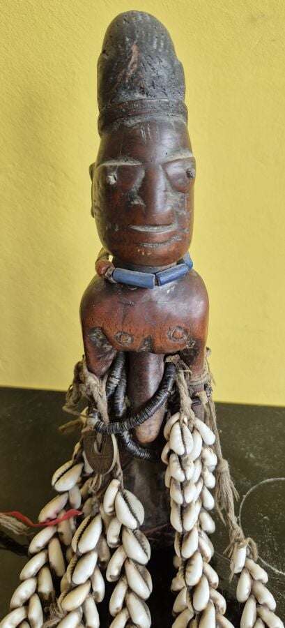 Ibedji. statuette masculine, le corps est réaliste. Les mains sont posées sur l…