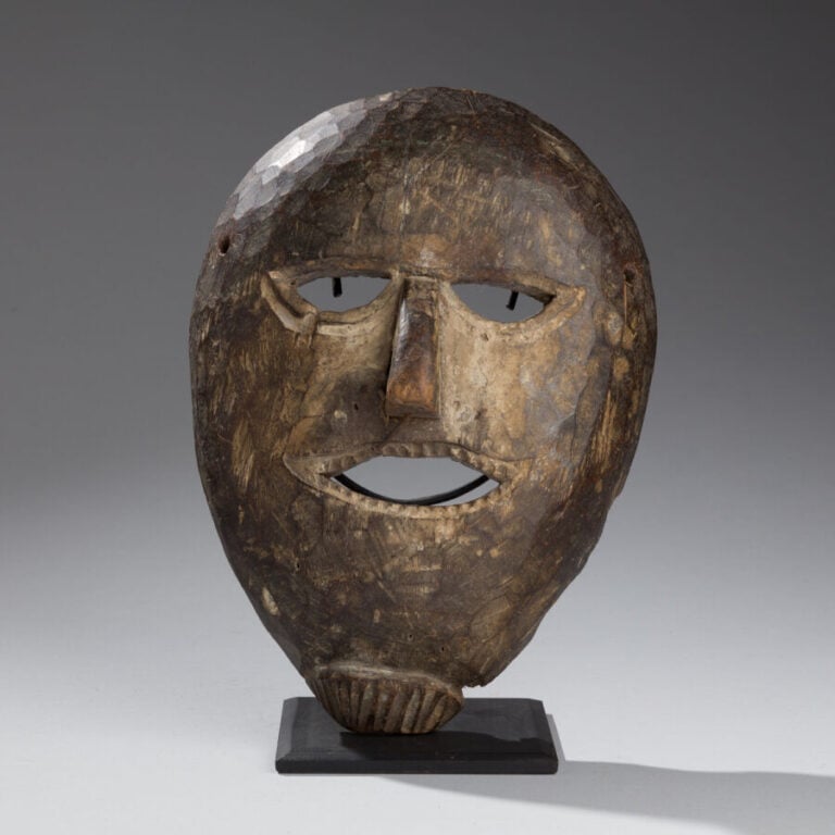 Masque chamanique de forme ovale. - Bois à patine brune. - Hauteur : 29 cm. - N…