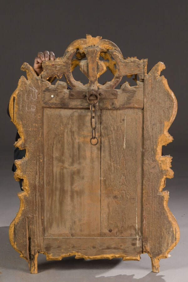 Miroir en bois doré à décor d'un vase fleuri au fronton, pampres de vigne, feui…