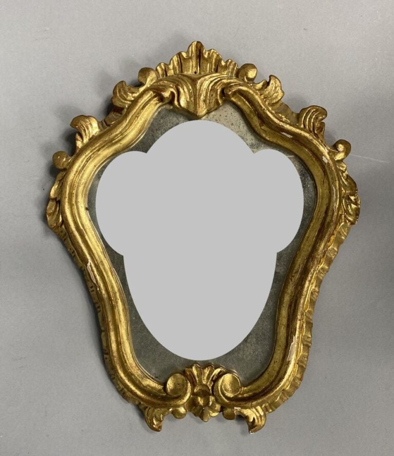 Miroir ovale en bois et composition doré à décor de frise surmonté d'une couron…
