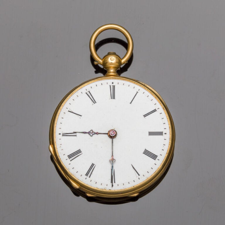 MONTRE de COL en or jaune (750‰) finement guilloché et ciselé. Cadran émail bla…