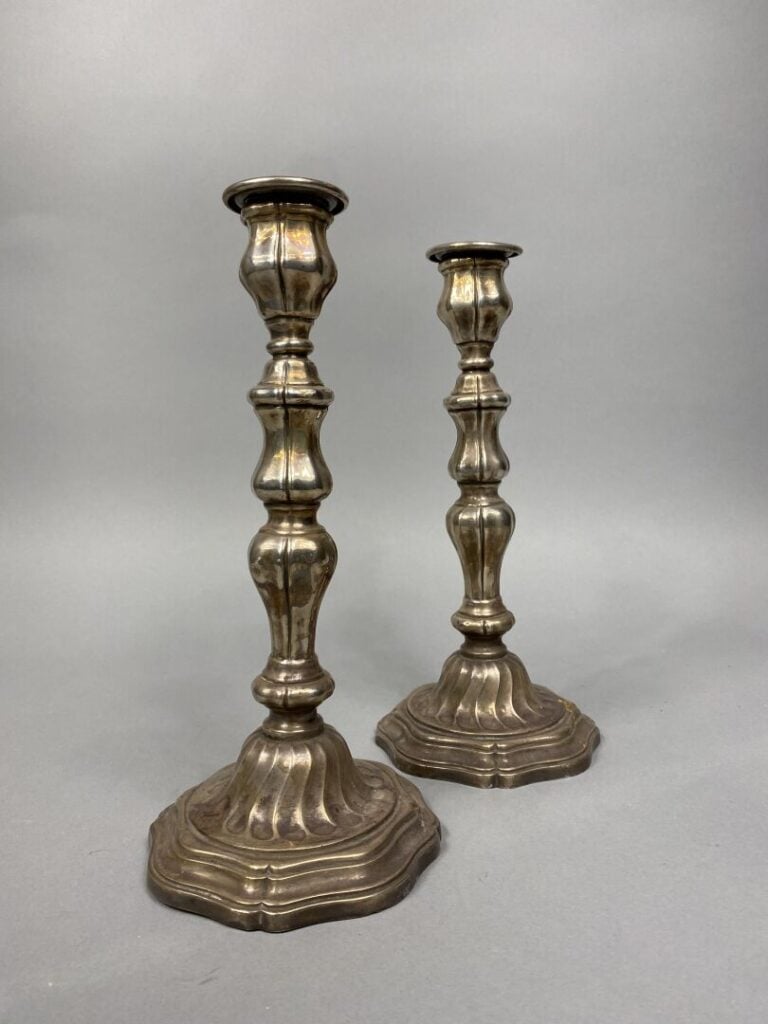 Paire de chandeliers en métal argenté, le fût balustre et le piédouche à bord c…