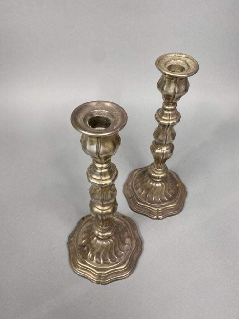 Paire de chandeliers en métal argenté, le fût balustre et le piédouche à bord c…