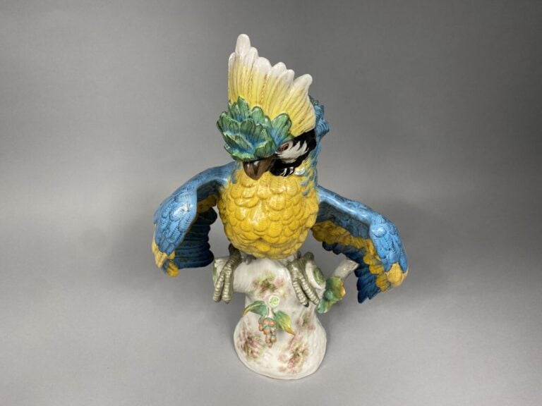PARIS - Perroquet en céramique polychrome, les ailes déployées reposant sur un…