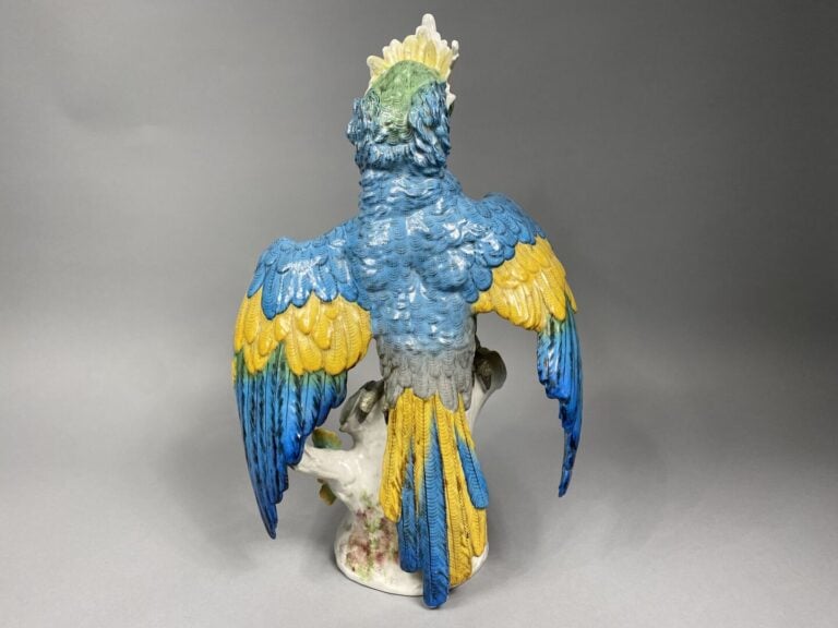 PARIS - Perroquet en céramique polychrome, les ailes déployées reposant sur un…