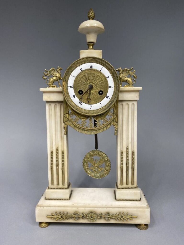Pendule portique en marbre blanc et bronze doré, les montants en forme de colon…