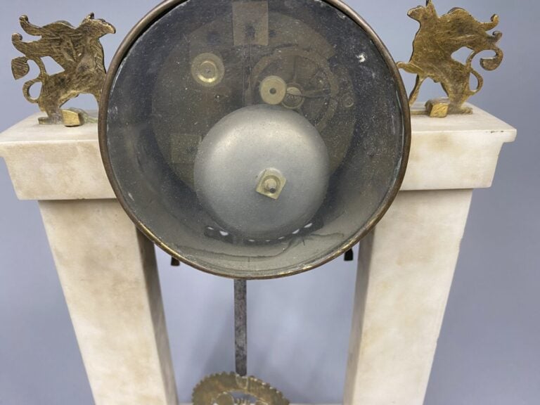Pendule portique en marbre blanc et bronze doré, les montants en forme de colon…
