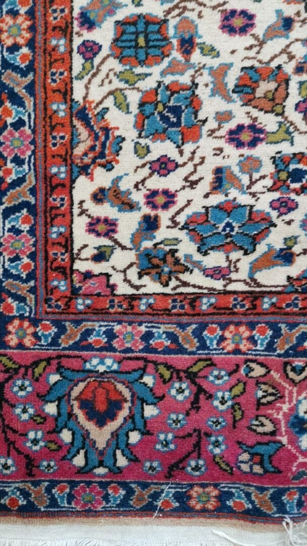 Perse - Tapis en laine à décor polychrome de rinceaux fleuris sur fond beige. L…