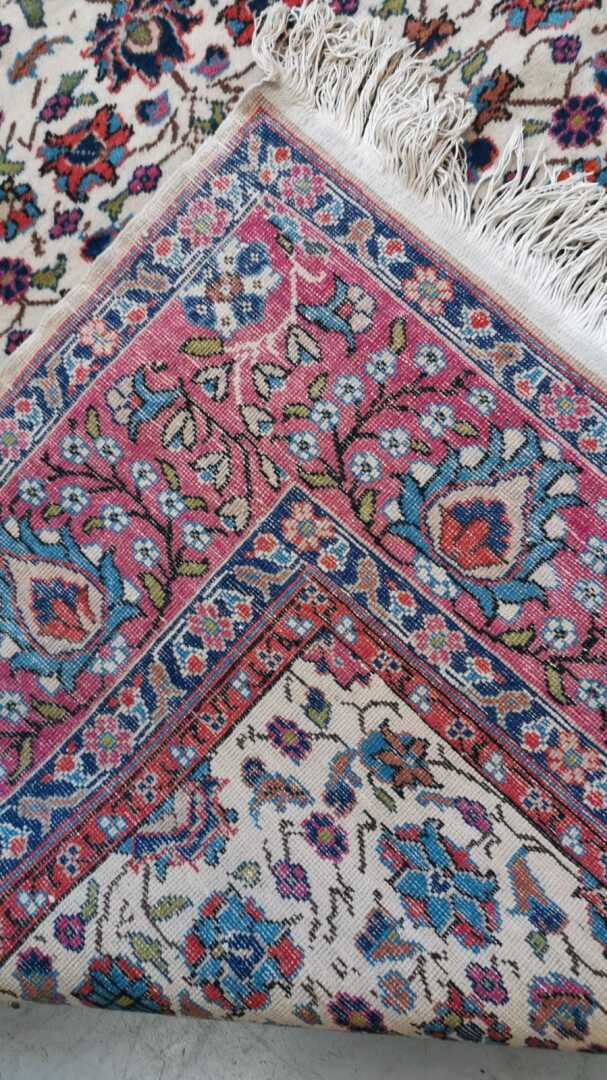 Perse - Tapis en laine à décor polychrome de rinceaux fleuris sur fond beige. L…
