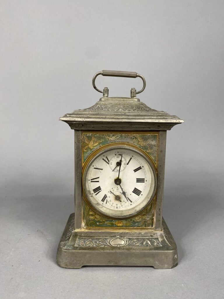 Petite pendulette en métal argenté à décor en relief de frises de fleurs de lys…