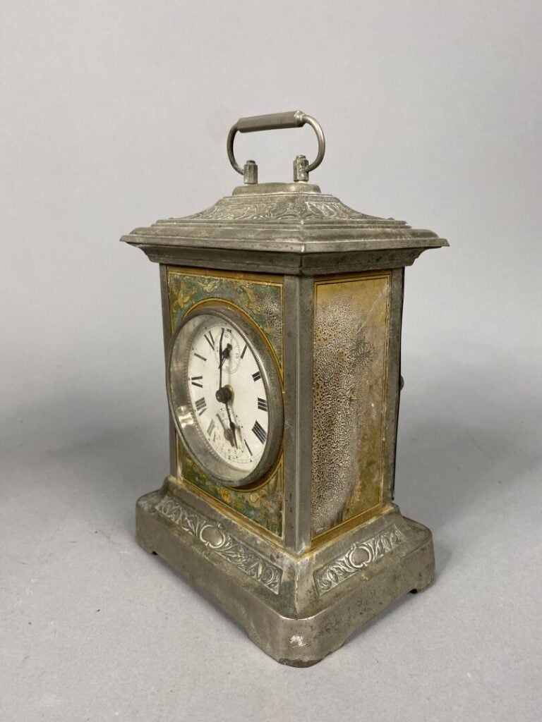 Petite pendulette en métal argenté à décor en relief de frises de fleurs de lys…