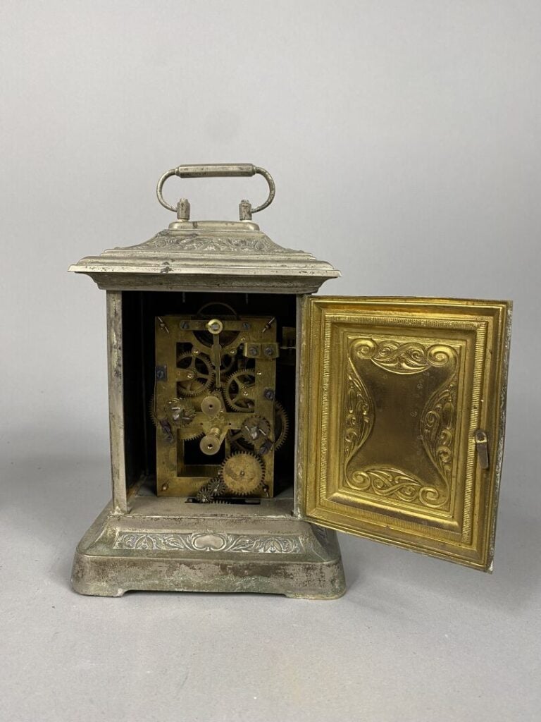 Petite pendulette en métal argenté à décor en relief de frises de fleurs de lys…