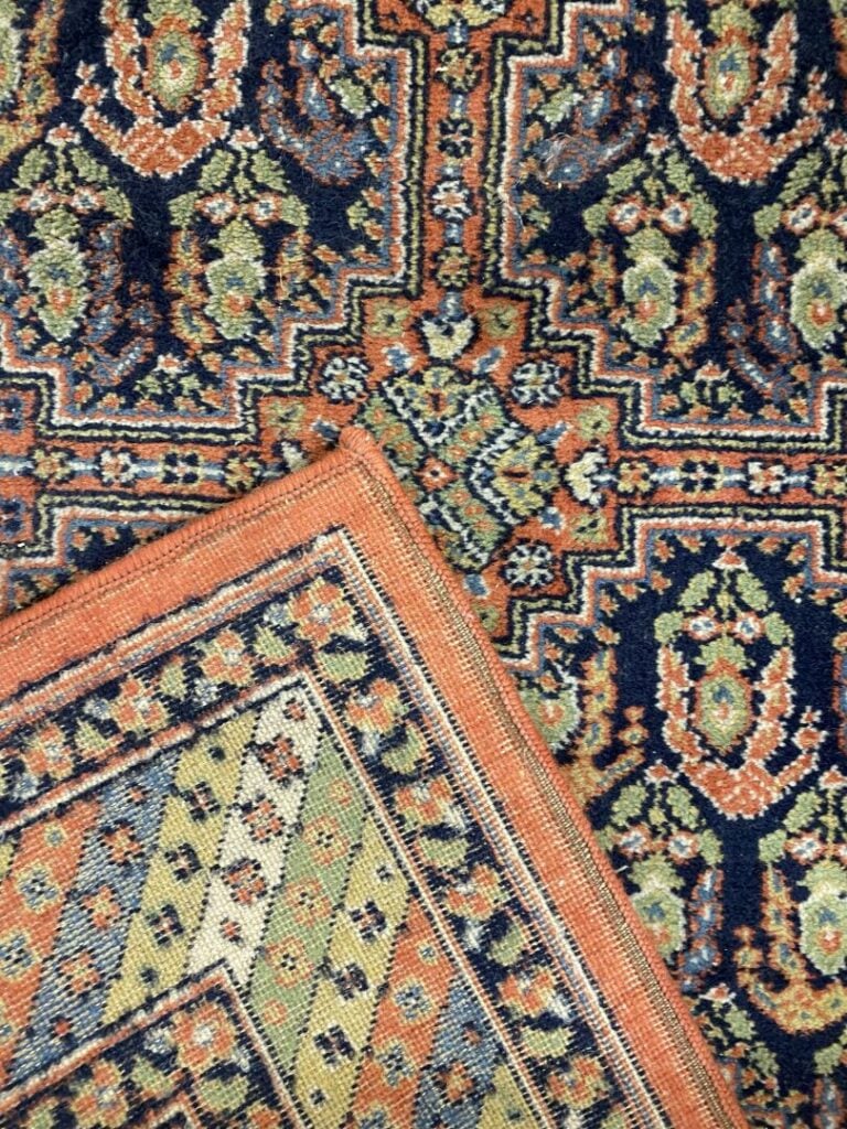 Tapis en laine à décor polychrome de frises de fleurs formant des motifs géomét…