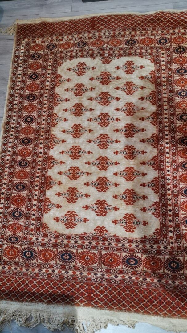 Tapis en laine à décor polychrome de frises de fleurs formant des motifs géomét…