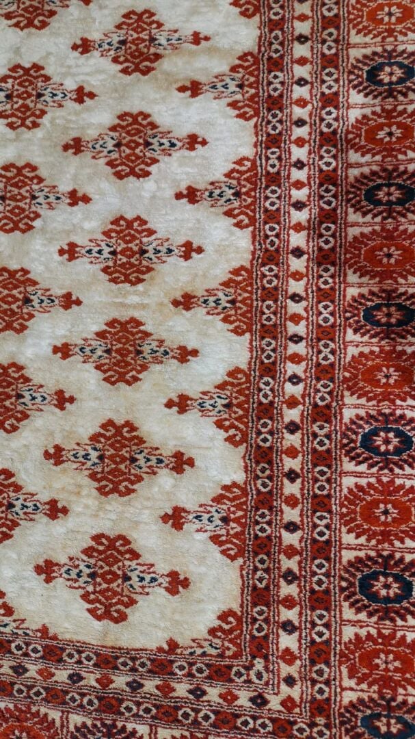 Tapis en laine à décor polychrome de frises de fleurs formant des motifs géomét…