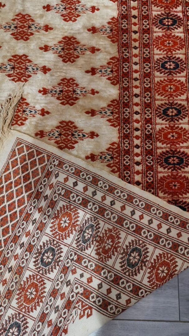 Tapis en laine à décor polychrome de frises de fleurs formant des motifs géomét…