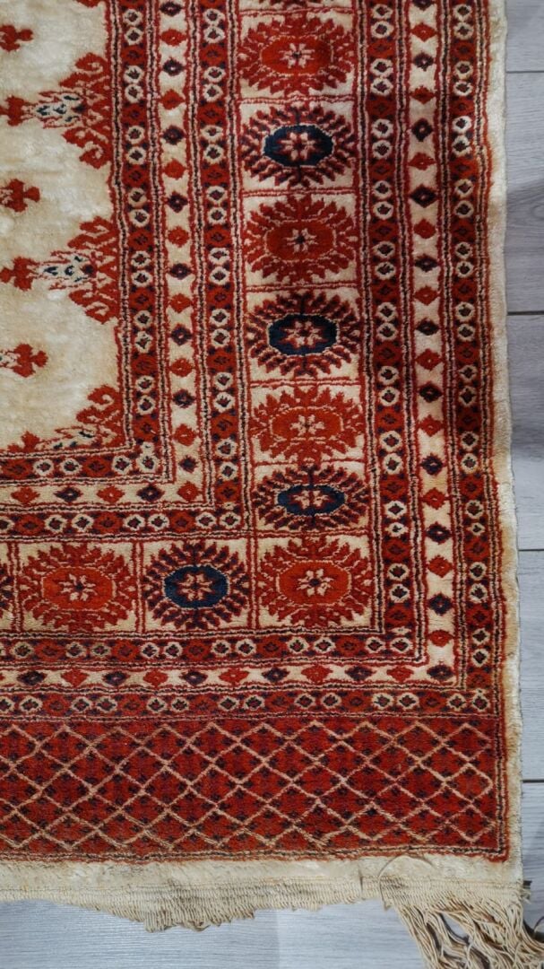 Tapis en laine à décor polychrome de frises de fleurs formant des motifs géomét…